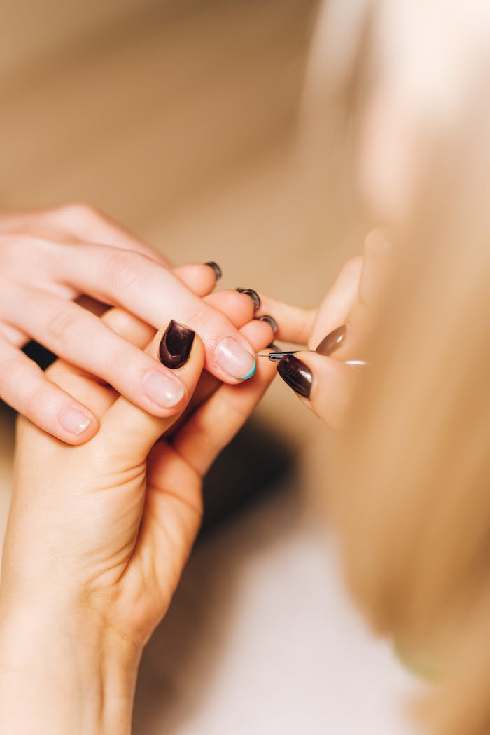 Detailed view of a professional manicurist working on a client's nails, showcasing nail care.